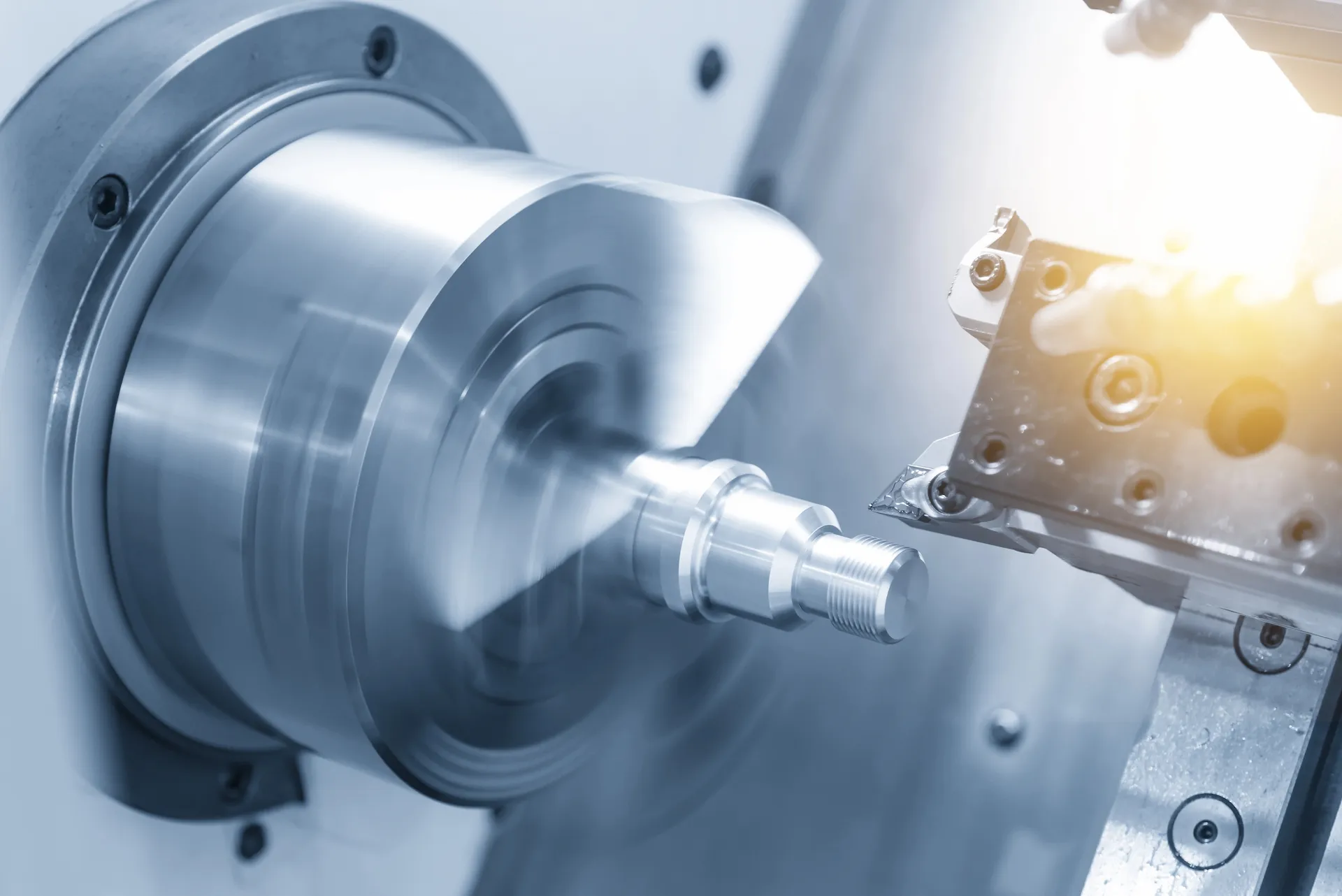 CNC-Drehmaschine beim Bearbeiten eines zylindrischen Metallteils mit hoher Präzision.