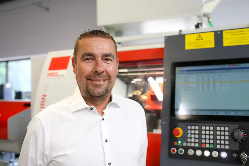 Marc Weisheit, Geschäftsführer, vor CNC-Maschine, zuständig für Materialbeschaffung und Angebote.
