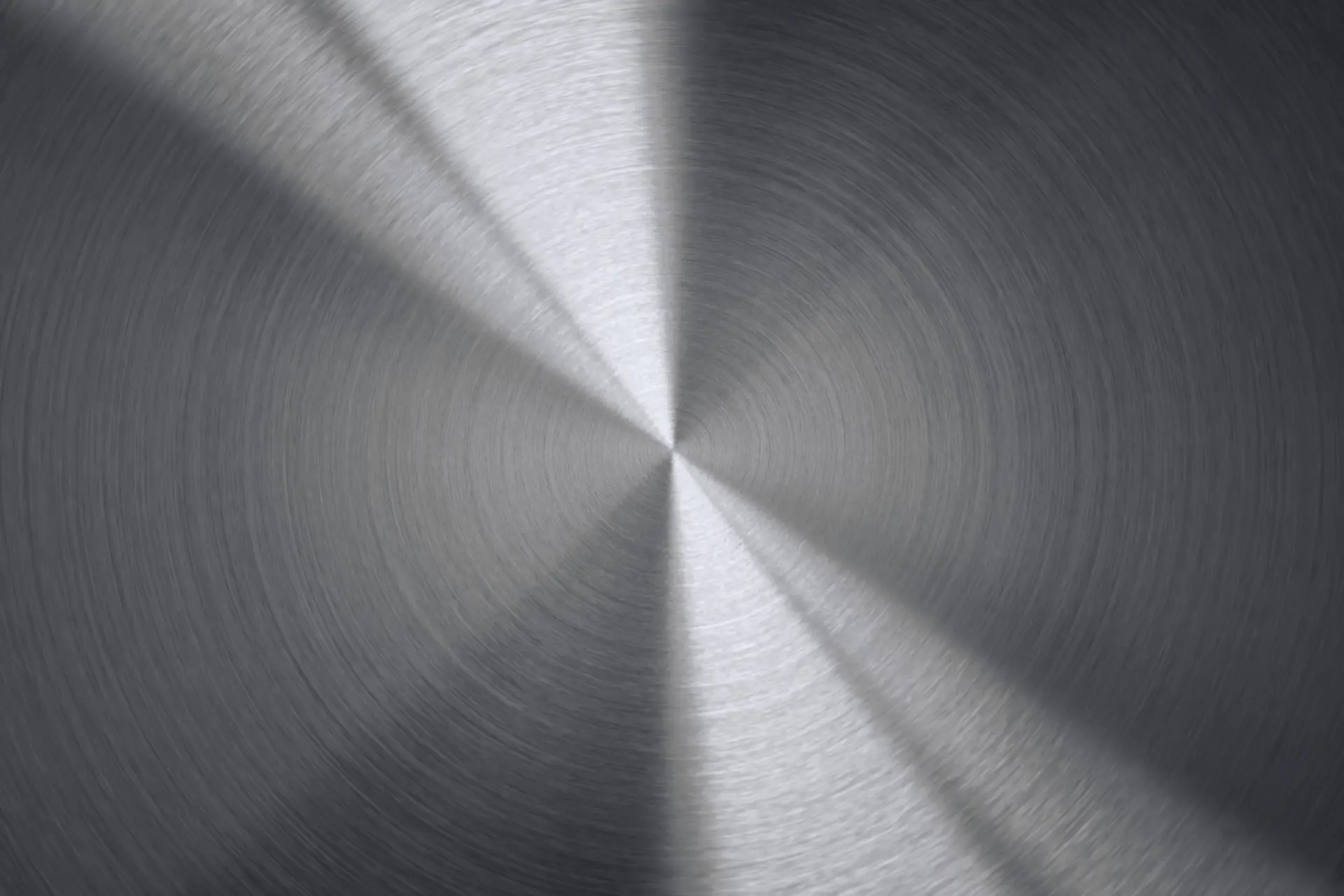 Detailaufnahme einer fein gedrehten, kreisförmigen Metalloberfläche als Symbol für Präzision und Qualität.